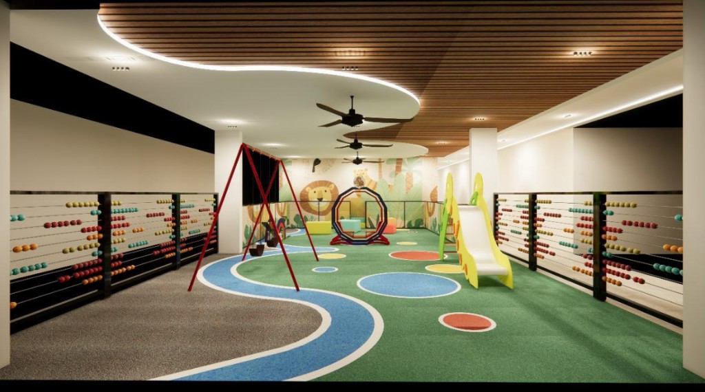 Indoor play area with safety flooring, swings, slides, and colourful equipment